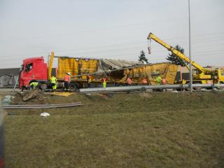 Vyprošťovací práce havarovaného nákladního automobilu se zdemolovaným návěsem.
